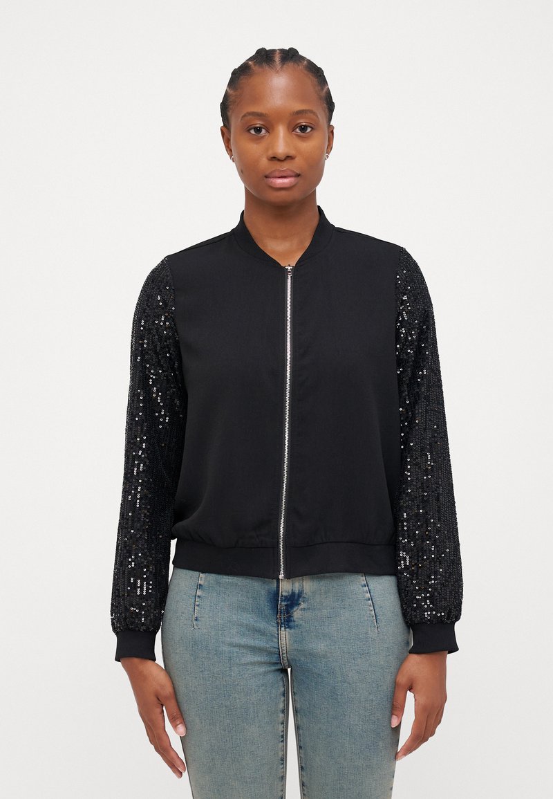 Veste bomber noire avec un corps lisse et des manches longues couvertes de sequins ; elle possède une fermeture éclair à l'avant et des poignets et un ourlet côtelés.