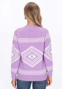 Lila trui met witte geometrische patronen, met een ronde hals, ribgebreide mouwen en onderrand. Zachte textuur, relaxte pasvorm en raglanmouwen.