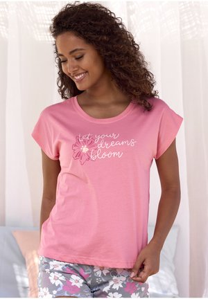 Pink cotton T-shirt with short sleeves, featuring white text "let your dreams bloom" and a floral design, paired with floral-print shorts.