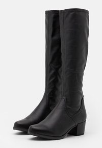 Bottes noires en similicuir montant jusqu'au genou, avec un bout pointu, des détails de couture subtils et un petit talon bloc. Texture lisse, forme structurée.