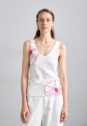 Débardeur blanc avec un col en V et un motif floral rose sur le côté gauche, présentant un ourlet côtelé. Silhouette simple et ajustée.