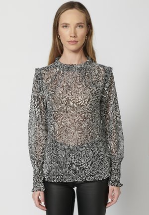 Schwarze und weiße durchsichtige Bluse mit wirbelndem Blumenmuster, gerafftem Halsauschnitt und elastischen Bündchen. Figurumspielender Stil mit leichtem Material.