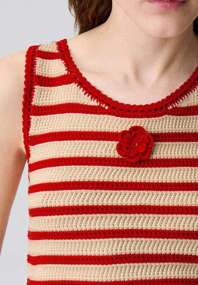 Top in cotone all'uncinetto con fasce alternate rosse e beige, scollatura rotonda e un accento floreale rosso sul davanti.