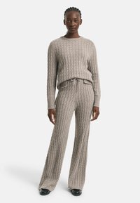 Grijs gebreid loungewear-set met een gestructureerd patroon, lange mouwen en wijde broekspijpen met een verstelbare trekkoord taille.