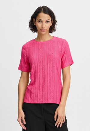 Haut à manches courtes rose avec un motif texturé et des détails en œillets, doté d'un col rond et d'une coupe décontractée.