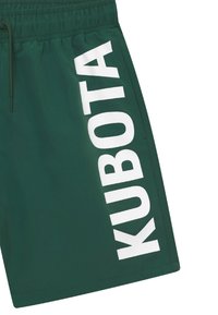 Zielone szorty kąpielowe z boczną łatą z dużym białym napisem "KUBOTA", elastycznym paskiem w talii oraz gładką, lekką fakturą materiału.