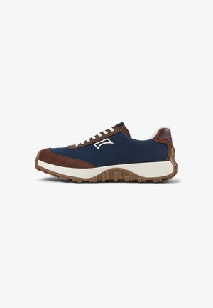 Sneaker basso con tessuto blu navy, dettagli in camoscio marrone, lacci bianchi, suola in gomma e battistrada marrone, vista laterale su sfondo bianco.