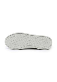 Semelle de sneaker en caoutchouc blanc avec un motif en chevrons, comportant des rainures pour une adhérence et un bord lisse. Texturée pour une prise et une durabilité.