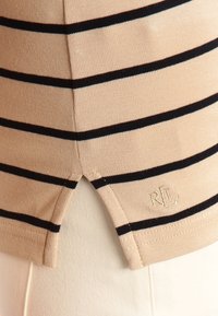 Beige and navy striped knit shirt with a split hem. Features ribbed texture and embroidered logo in a corner. Smooth fabric composition.