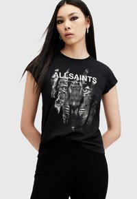 Camiseta de algodón negra con un gráfico de tigre y texto "ALLSAINTS". Mangas cortas, cuello redondo, corte holgado, con una textura suave.