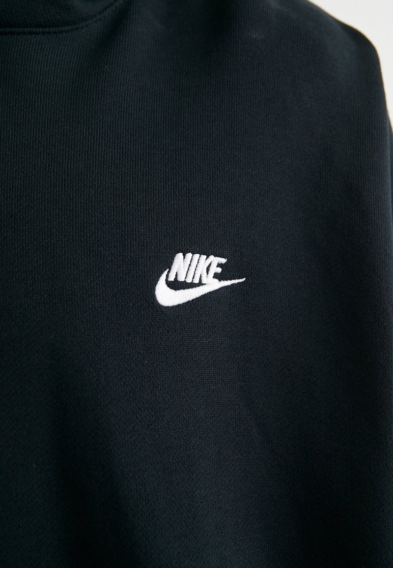 Sweatshirt noir en tissu doux avec un logo Nike brodé blanc sur la poitrine, un col rond et des détails côtes.