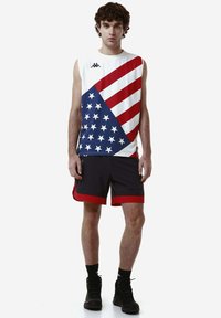 Canottiera sportiva senza maniche con un design a stelle e strisce rosso, bianco e blu, abbinata a pantaloni corti neri con orlo rosso.