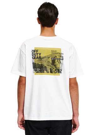 Biała bawełniana koszulka z grafiką na plecach z żółtym i czarnym napisem, w tym "OFF DUTY GEAR" oraz motywami górskimi.