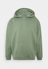 Sweat à capuche vert en tissu doux, doté d'une grande poche frontale, d'une capuche à cordon de serrage et de poignets côtelés. Design simple avec une coupe décontractée.