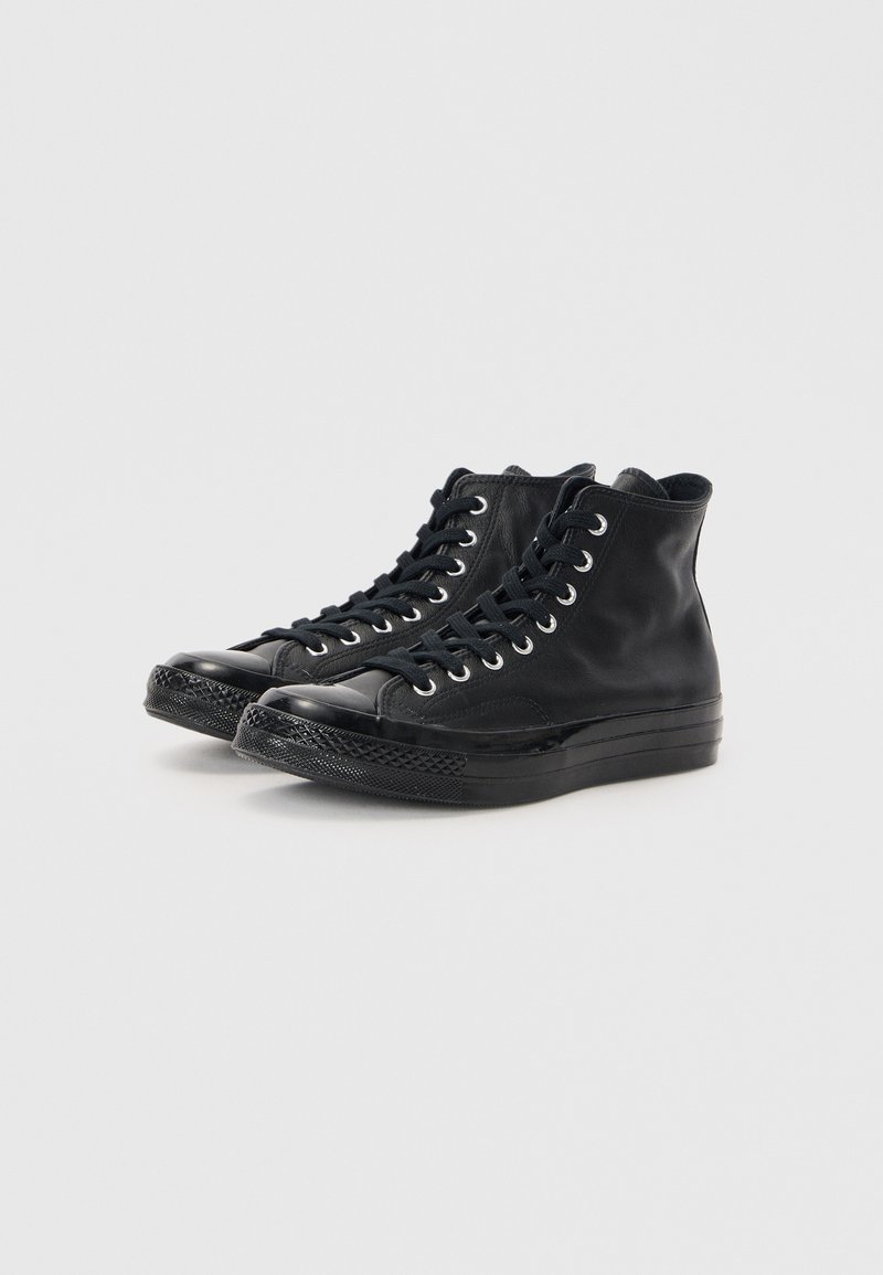 Hochschwarze Sneakers aus glattem Leder mit runder Zehenpartie, Metallösen für die Schnürsenkel und strukturiertem Gummisohle.
