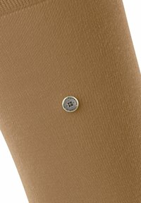 Chaussette marron jusqu'au genou avec une texture côtelée et un emblème de marque rond en argent près du haut, présentant un design en croix au centre.