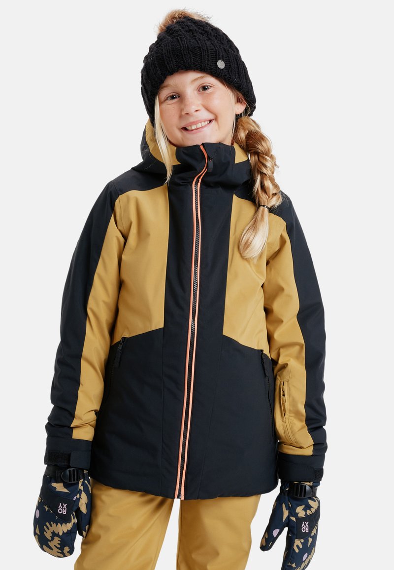 Waterdichte skijas in zwart en geel, met een oranje rits en ritszakken. Een paar gestreepte handschoenen en een gebreide zwarte muts.