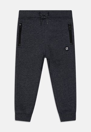 Pantaloni di felpa grigio scuro con vita regolabile tramite coulisse, polsini a coste e due tasche laterali con zip. Presenta un piccolo dettaglio con logo.