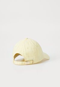 Casquette en coton jaune avec une visière courbée, sangle ajustable et fermoir métallique. Présente des trous de ventilation pour la respirabilité. Design simple.