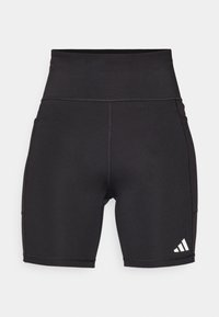 Pantaloni sportivi neri con vita alta, realizzati in un materiale elasticizzato. Presentano un piccolo logo Adidas bianco e cuciture piatte.