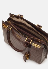 Bruine handtas van croco-embossed leer met goudkleurige hardware, dubbele handgrepen, ritscompartimenten en merkaccenten aan de voorkant en op de binnenvoering.