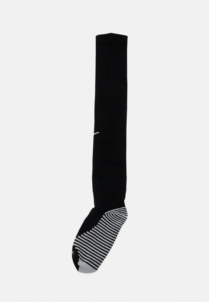 Chaussette noire montante avec un design ajusté, semelle rayée grise contrastante et un logo blanc près du haut. Texture lisse sur l'ensemble.