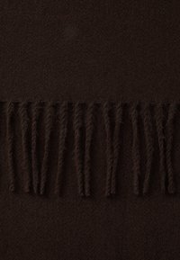 Tissu marron foncé avec une texture douce, présentant des bords frangés le long du bas, créant une apparence chaleureuse et confortable.