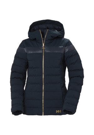 Chaqueta acolchada azul marino con capucha, con textura acolchada, cierre de cremallera dorada y franjas brillantes en los hombros. Logo visible en el lateral.