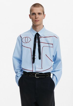 Light blue button-up shirt featuring red outline design, black tie, and pocket detail. Paired with dark pants and a black belt with stitching.