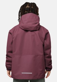 Person with braided hair wearing a maroon hooded jacket viewed from the back with hands relaxed at the sides.