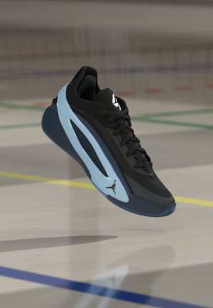 Fekete és kék sportcipő fűzőkkel, középtalp dizájnnal és Jumpman logóval, lebegve egy beltéri sportpálya padlója felett.