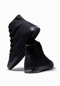 Svarta högskaftade sneakers i canvas med texturerade gummisulor. Funktioner inkluderar snörning på sidan och en logotagg på hälen.