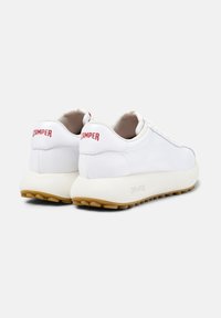 White leather sneakers with a textured sole, round toe, and red "CAMPE" branding on the back. Smooth upper and cushioned interior.