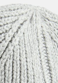 Hellgraue, gestrickte Mütze mit geripptem Muster und spiralförmigem Oberteil, das hervorstehende Zopfmuster aufweist.