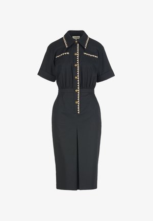 Black short-sleeve midi dress with gold buttons, cream zigzag trim on collar, chest pockets, and front placket, with a front slit.