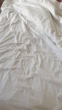 Wrinkled white fabric, likely cotton, with soft texture and light, airy appearance; loosely draped with subtle creases and folds.
