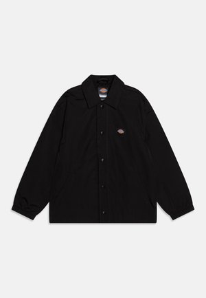 Crna vanjska jakna s ovratnikom, zatvaranjem na gumbe i elastičnim manžetama. Ima dva bočna džepa i logo na lijevoj strani prsnog koša.