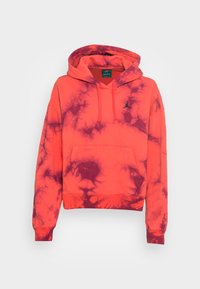 Orange og lilla tie-dye hoodie med en kenguru-lomme, ribbede manchetter og et lille sort logo på brystet. Blød stofstruktur.