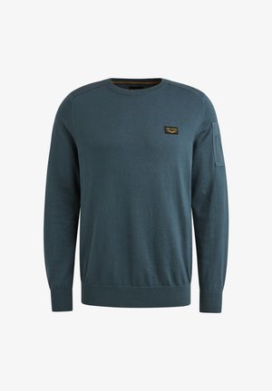 Blue knitted sweater with a round neck, long sleeves, and ribbed cuffs. Features a small logo patch on the chest and textured fabric.