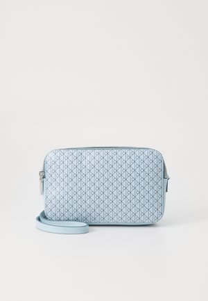 Sac bracelet rectangulaire bleu clair avec motif géométrique de lignes noires et tirette de fermeture éclair argentée sur fond blanc uni.