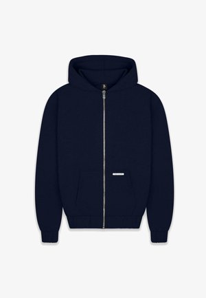 Navy zip-up hoodie with a large hood, front pouch pocket, ribbed cuffs and hem, and a small label accent on the front. Soft fabric texture.