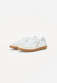 Hvit og beige sneakers med en blanding av lær og semsket skinn. Utstyrt med gummisåle, snøring og glatt overflatedesign.