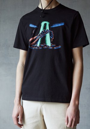 T-shirt en coton noir avec un graphique coloré d'une voiture et d'une tour verte contre un ciel bleu, à manches courtes et col rond.