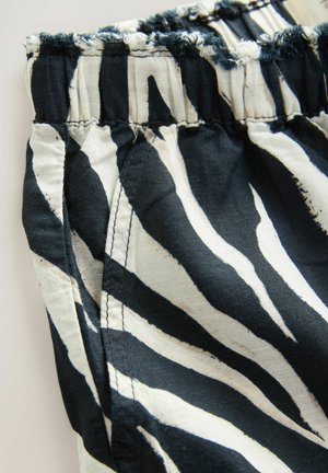 Shorts med elastisk talje i et sort og hvidt zebra-stribe mønster, lavet af letvægtigt stof med en frynset kant og pæne sømme.