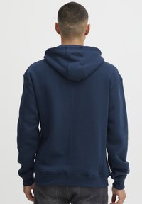 Mörkblå hoodie i bomullsblandning, med en känguruficka, dragsko i huvan och ribbade ärmslut och nederkant; enfärgad struktur.