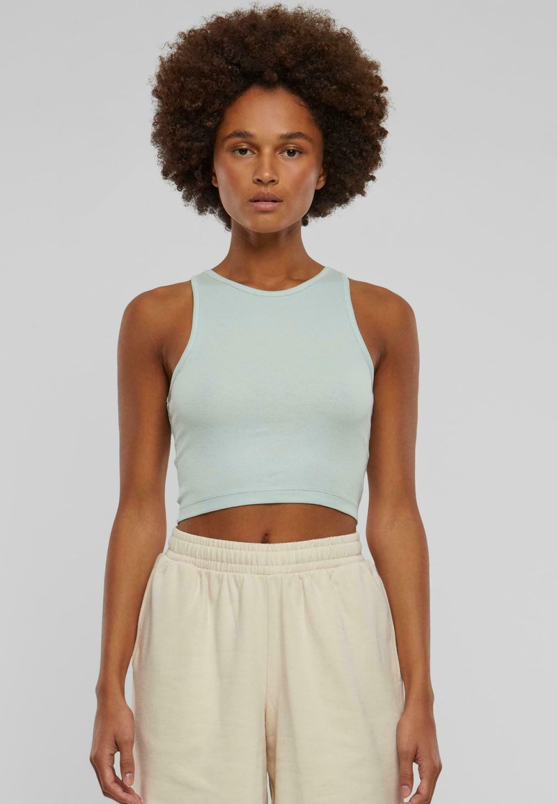 Light blue cropped tank top made of ribbed fabric, featuring a round neckline and sleeveless design, paired with beige elastic waistband pants.