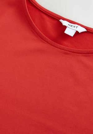Tricou roșu din bumbac, cu o textură netedă, având un decolteu rotund și etichetă la spate. Design simplu, fără modele sau accente.