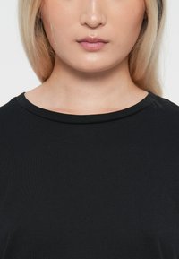 Zwarte katoenen t-shirt met een ronde halslijn en korte mouwen, met een gladde textuur en een eenvoudig, klassiek ontwerp.