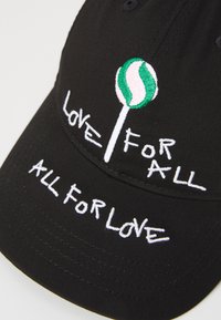 Schwarze Baseballmütze mit besticktem grünen und rosa Lollipop-Design. Der Text lautet "LIEBE FÜR ALLE" und "ALLE FÜR LIEBE" in Weiß. Twill-Textur.