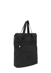 Sac fourre-tout en nylon noir avec deux poignées en textile, une poche zippée à l'avant et un badge logo circulaire. Texture lisse avec une forme rectangulaire élégante.
